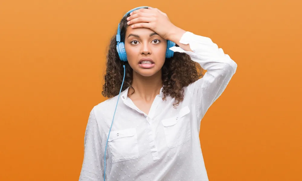 Frustrated language learner wearing headphones, struggling with pronunciation practice